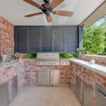 Custom outdoor kitchen area by swimming pool