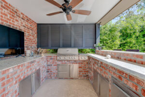 Custom outdoor kitchen area by swimming pool
