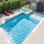 Rectangle inground swimming pool with raised spa and water feature wall | Lafayette, LA