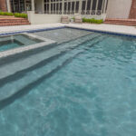 Custom inground gunite pool in Lafayette, LA with a sunken spa | glass tile and tanning ledge