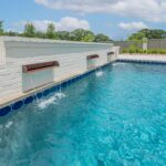 Water feature in Lafayette, LA, custom swimming pool, copper scuppers on a water feature wall