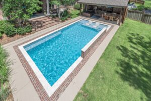 Rectangle custom inground swimming pool with natural stone coping | Lafayette, LA