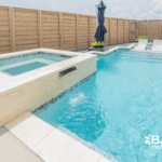 Custom courtyard pool with integrated spa, tanning ledge, and modern design in a private backyard by Bask Pools in Lafayette, LA