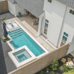 Custom courtyard pool with integrated spa, tanning ledge, and modern design in a private backyard by Bask Pools in Lafayette, LA