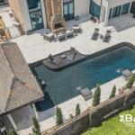 Complete pool renovation with fire and water feature, tanning ledge and modern finishes by Bask Pools – expert pool remodeler in Lafayette, LA