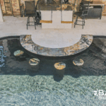 Complete pool renovation with fire and water feature, tanning ledge and modern finishes by Bask Pools – expert pool remodeler in Lafayette, LA