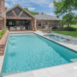 Custom-built inground pool with spa and water features by Bask Pools, a pool builder in Lafayette, LA