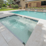 Custom-built inground pool with spa and water features by Bask Pools, a pool builder in Lafayette, LA