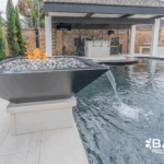 Complete pool renovation with fire and water feature, tanning ledge and modern finishes by Bask Pools – expert pool remodeler in Lafayette, LA