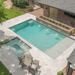 Custom-built inground pool with spa and water features by Bask Pools, a pool builder in Lafayette, LA