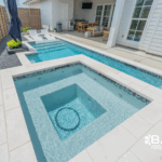 Custom courtyard pool with integrated spa, tanning ledge, and modern design in a private backyard by Bask Pools in Lafayette, LA