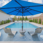 Luxury custom backyard pool with built-in umbrella, tanning ledge by Bask Pools in Lafayette, LA