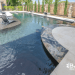 Complete pool renovation with fire and water feature, tanning ledge and modern finishes by Bask Pools – expert pool remodeler in Lafayette, LA