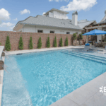 Stylish custom backyard pool with built-in umbrella, tanning ledge by Bask Pools in Lafayette, LA