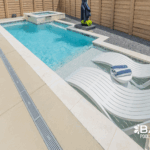 Custom courtyard pool with integrated spa, tanning ledge, and modern design in a private backyard by Bask Pools in Lafayette, LA