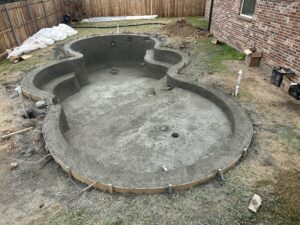 Freshly applied gunite pool shell at a custom residential pool build by Bask Pools + Outdoors in Lafayette, LA. Showcasing durable gunite construction and freeform custom pool design.